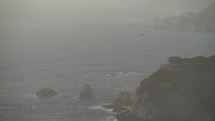 Bird Flying over Misty Coastline of Carmel By The Sea and Big Sur - a Rugged Stretch of California Central Coast known for Winding Roads and Seaside Cliffs