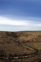 Winding road through desert prairie land.