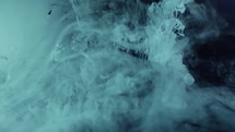 Blue cosmic nebula falling underwater against black screen - paint ink effect	