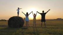 Silhouette family. Teamwork. Parents and children in a wheat field at sunset. Family farming. Beautiful sunset on a wheat field. Happy family in agriculture. Successful family business concept.