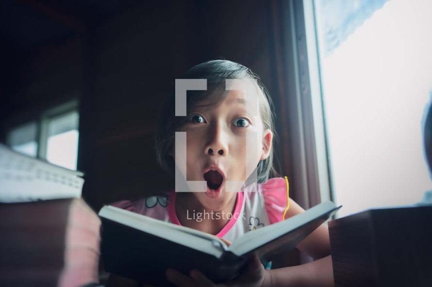 Surprised girl  reading the Bible