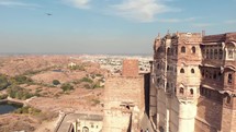 view of Mehrangarh Fort's facades overlooking the terraces and features surrounded by prey birds - Aerial Orbit shot