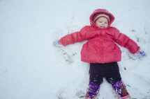 toddler making a snow angel 