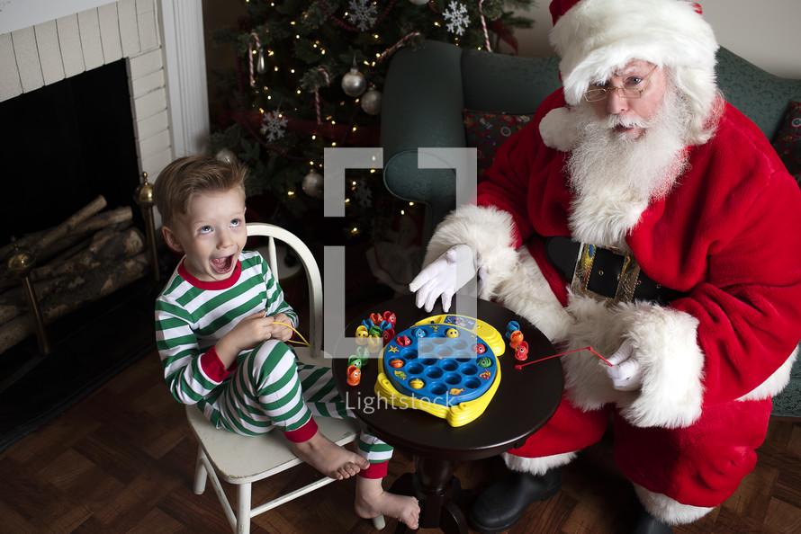 Santa and a little boy playing with toys 