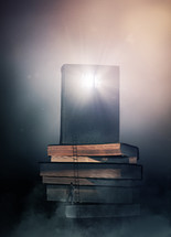 man climbing a stack of books with glowing Bible on top 
