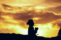 silhouette of a praying girl 