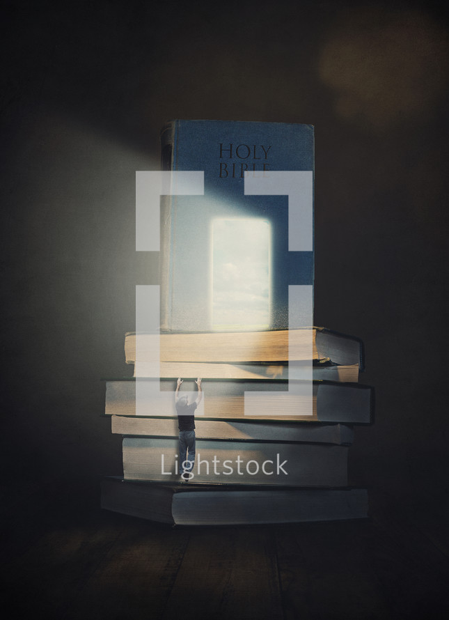 Man climbing up a stack of books to reach the light shining on The Bible.
