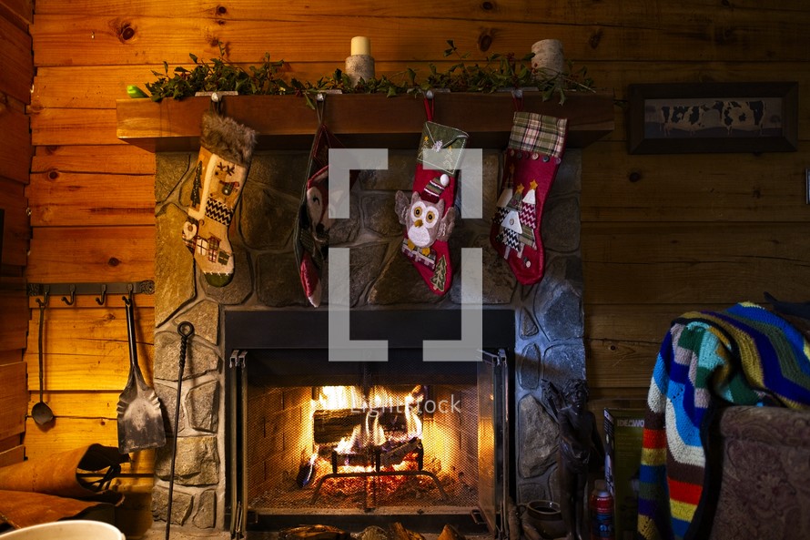 Christmas stocking hanging over a fireplace in a cabin 