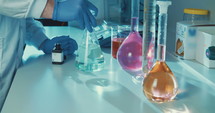 Slow motion of lab Technician mixing chemicals in a lab