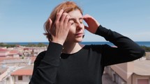 Woman Dressed In Black With Red Hair Looking Out At The Terrace