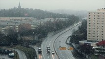 snow falling over a highway in a city 