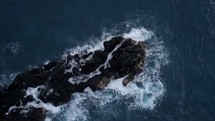 Ocean waves crash against a rocky peninsula 