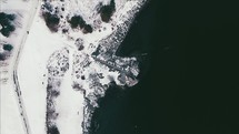 a drone flying over a snowy coastline 