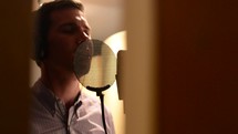 Man singing in a recording studio.