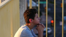 A male teenager in prayer and deep thought
