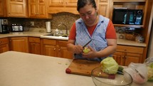 A mature Asian woman preparing food in a kitchen 