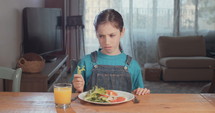 Girl refusing to eat healthy food.