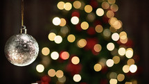 Golden Christmas Ball on blurred tree copy space background