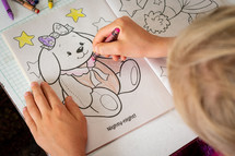 a child coloring in a coloring book 