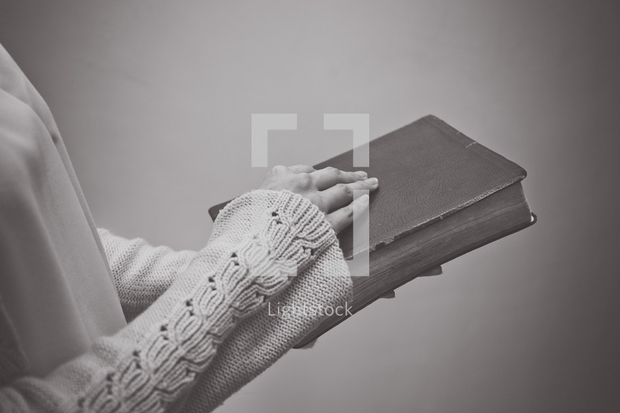 a woman holding a Bible in front of her 