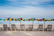 lounge chairs and beach umbrellas on a beach 