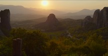 The sun sets on Meteora, Greece. Gentle gimbal pan up to reveal the incredible landscapes.
