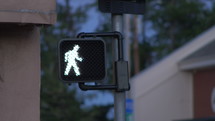 A pedestrian sign at a crosswalk in a city