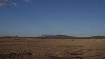 Aerial of a vast prairie with mountains in the distance