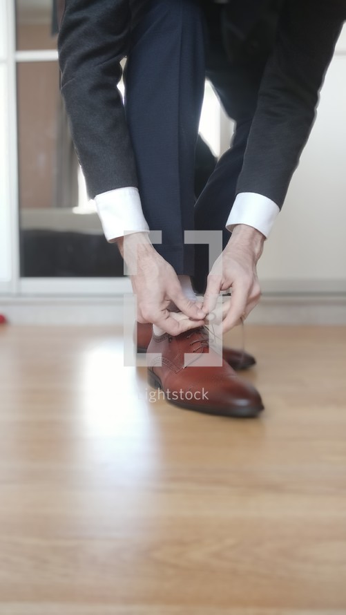 Blurred Businessman tying the shoelaces on his brown shoes