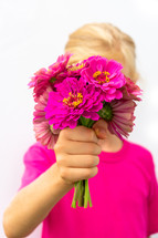 a girl holding a bouquet of fuchsia flowers