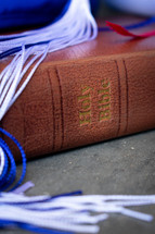 blue graduation cap and Bible 