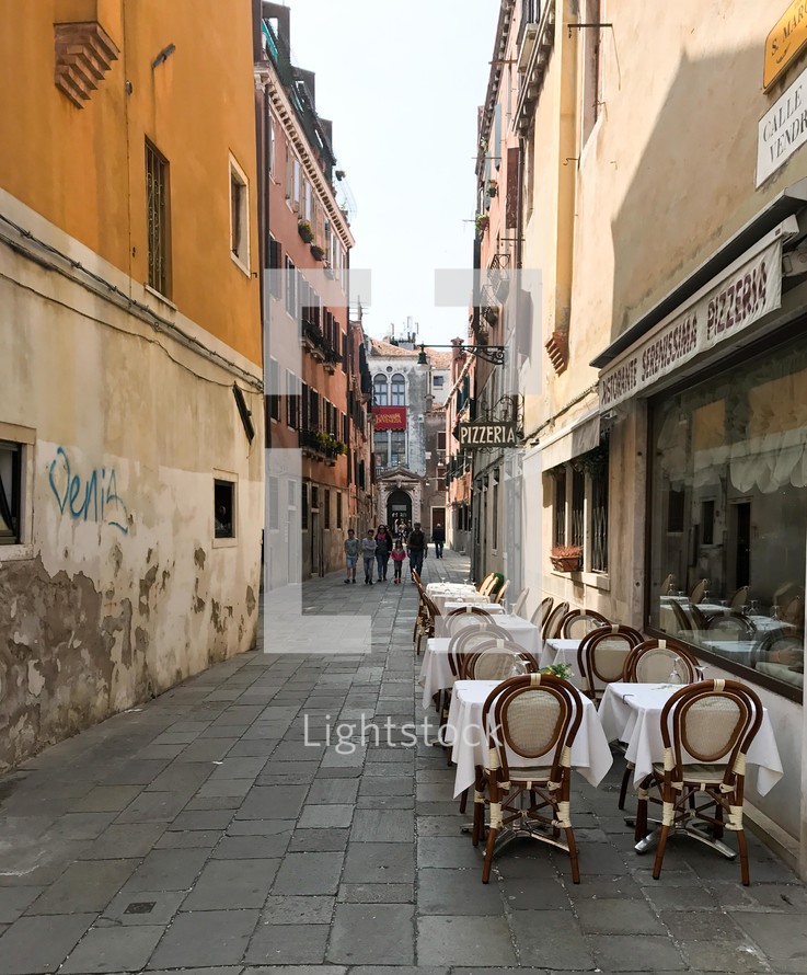 outdoor seating at a restaurant in a narrow alley 