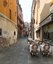 outdoor seating at a restaurant in a narrow alley 