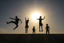 silhouettes of kids jumping 