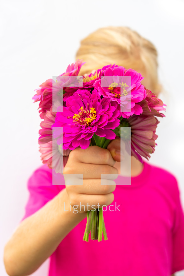 a girl holding a bouquet of fuchsia flowers