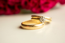 gold wedding rings and rose petals 