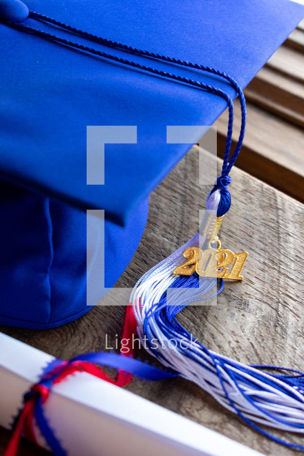 blue graduation cap with 2021 tassel and diploma 