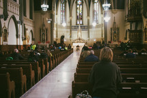 A woman praying during mass at a Catholic church