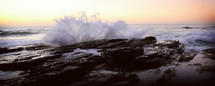 powerful waves crashing into rocks on a shore