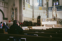 A young Catholic man praying at Eucharistic adoration in a Catholic church