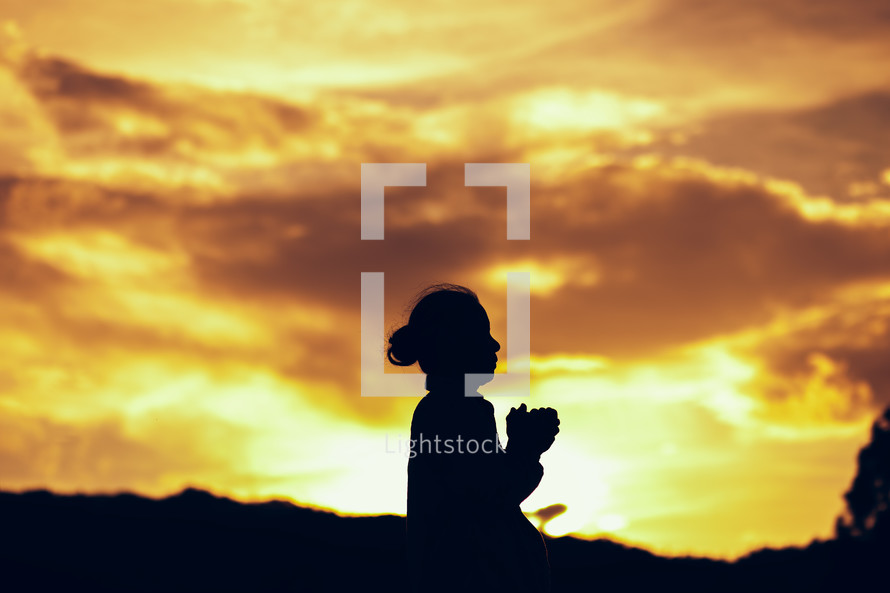 silhouette of a praying girl 