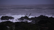waves crashing into rocks on a shore 