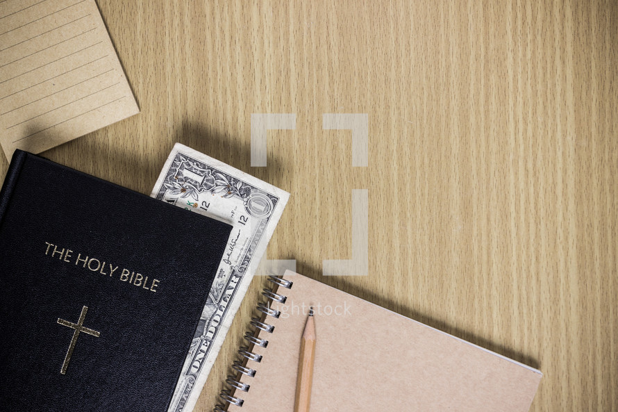 dollar bill in the pages of a Bible 