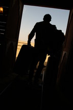 man boarding a train with luggage 