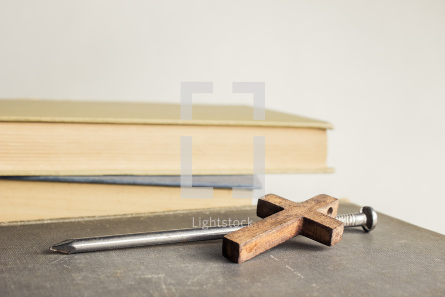 nail and cross next to books 