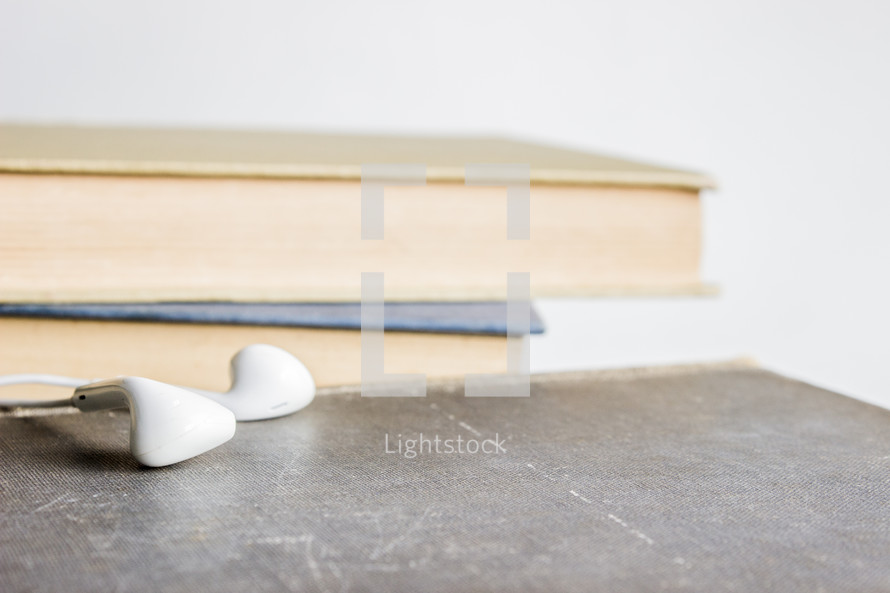 earbuds next to books 
