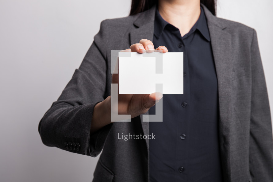 a woman holding up a blank business card 