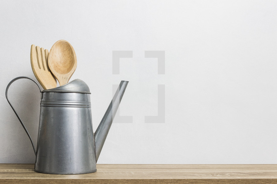 wooden kitchen utensils in a watering can 