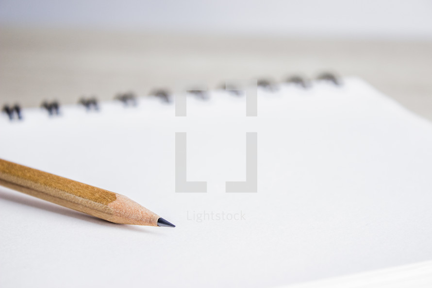 sharpened pencil on a notepad 