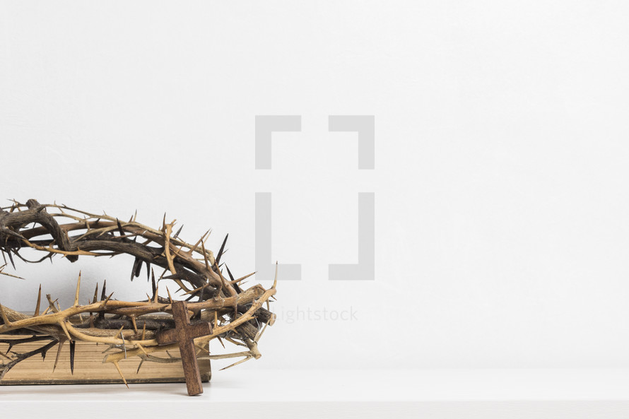 crown of thorns and cross on a Bible 